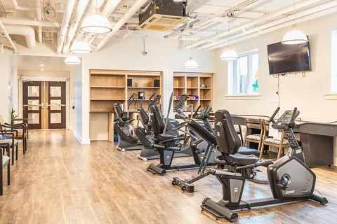 Fitness room with exercise bikes, windows and open shelving