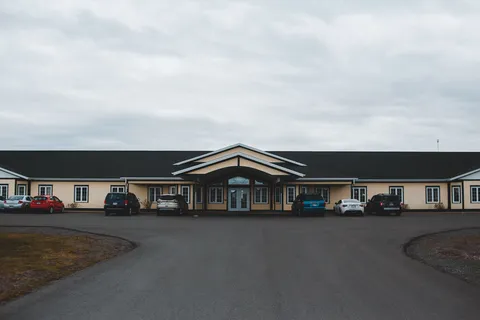 Residence exterior with a covered entrance and parking area.