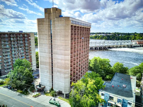 Aerial view of the residence tower beside the river and a road.