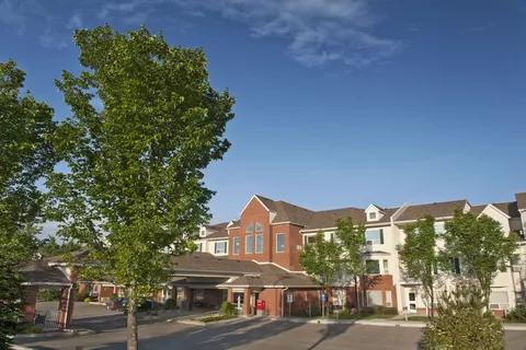 Residence exterior and covered entrance beside mature trees