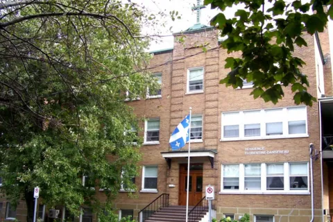 Brick residence entrance with a Quebec flag