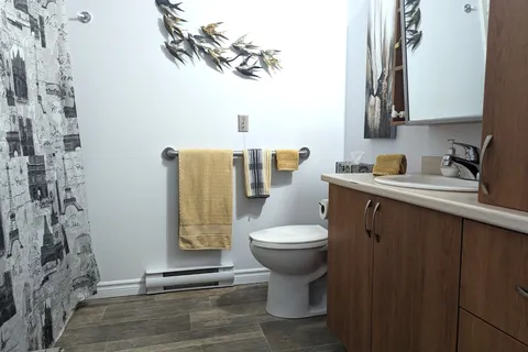 Bathroom with a sink, toilet, shower curtain and yellow towels