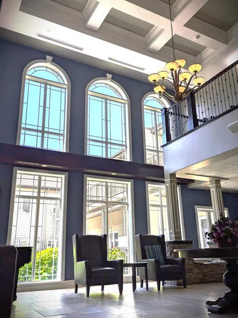 Seating area beneath tall arched windows and a chandelier