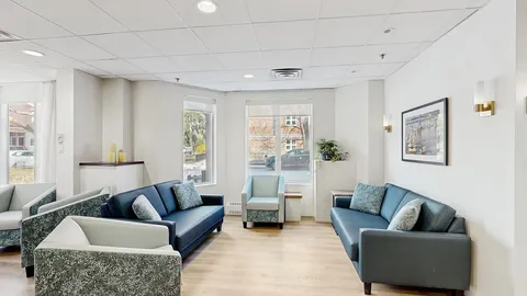 Sitting area with two blue sofas and window seating.