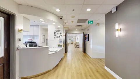 Reception area with a curved desk and corridor.