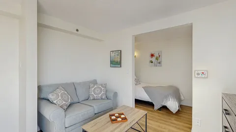 Studio with a sofa, coffee table and bed in an alcove.