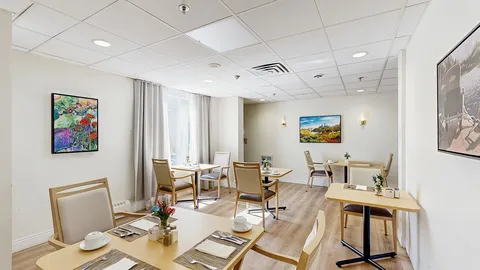 Small dining area with set tables beside windows.