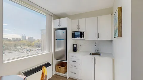 Suite kitchenette with white cabinets and a refrigerator.