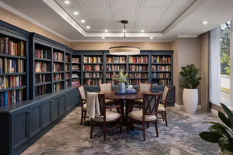 Library with bookcases, reading table and chairs.