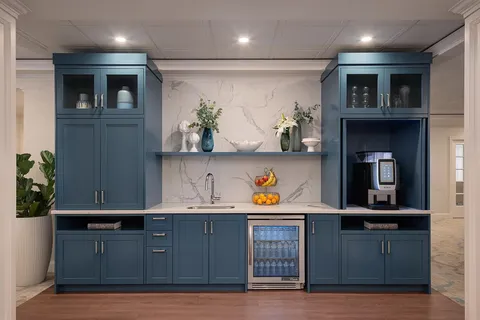 Bistro counter with blue cabinets, a sink and beverage appliances.