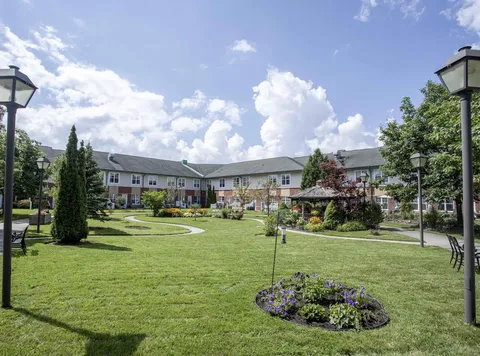 Lawn, flower beds and paths in a courtyard beside the building