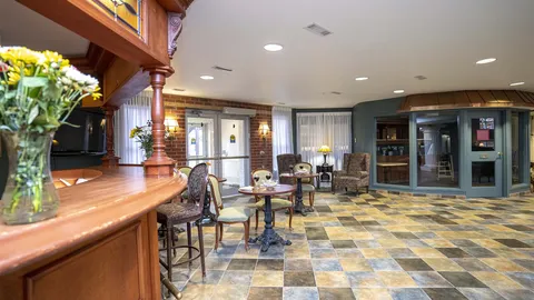 Armchairs and tables beside a wood bar counter