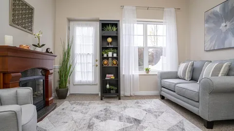 Sitting area with a sofa, fireplace, shelving and a glazed door