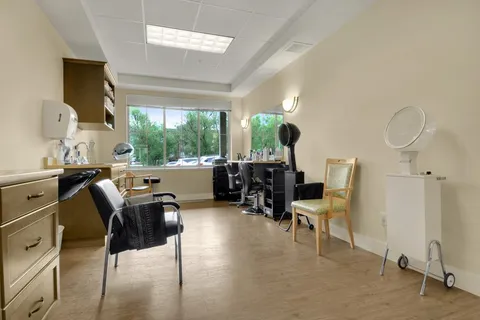 Salon with black chairs, mirrors and a hair-washing sink