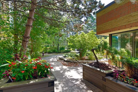 Garden path beside raised planters and mature trees.