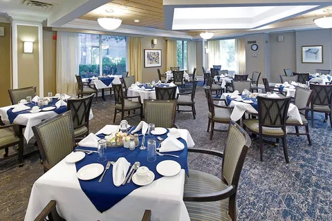 Dining room with set tables and blue table coverings.