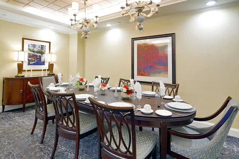 Private dining room with a long set table beneath chandeliers.
