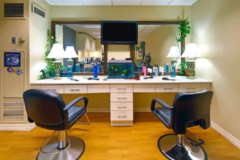Salon with two styling chairs and a long mirror.