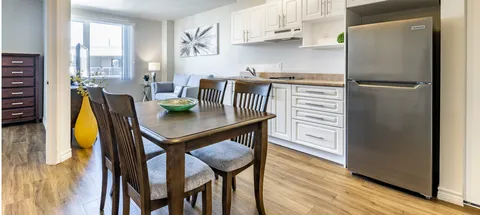 Kitchenette with wooden dining table and chairs beside a window