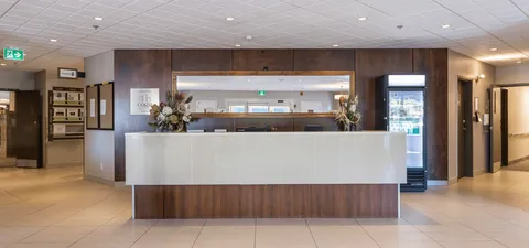 Reception counter with flowers beneath a patterned feature wall