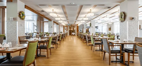 Dining room with rows of tables, chairs and large windows