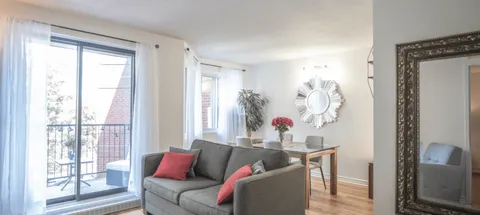 Living room with a sofa, armchair and balcony doors.