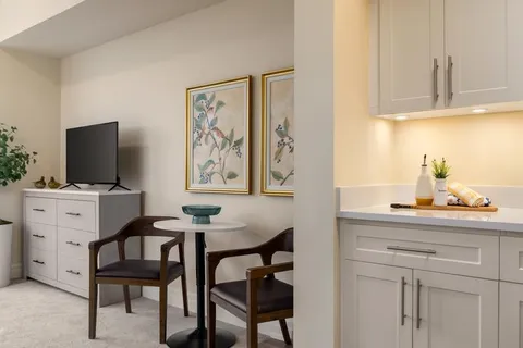 Suite kitchen and dining area with a small table and television.