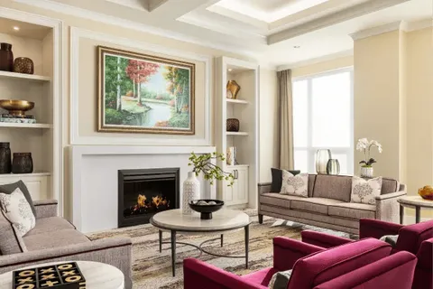 Lounge seating and coffee tables beside a fireplace.