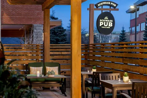 Covered pub patio with tables, chairs and timber screening.