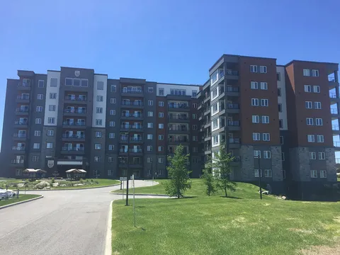 Multi-storey residence with balconies beside a lawn and driveway