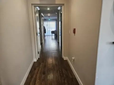 Hallway with wood flooring and an open doorway