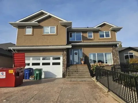 Two-storey residence with a garage, front steps and a metal access ramp