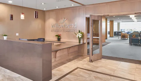 Reception counter beside open glass doors leading to a lounge