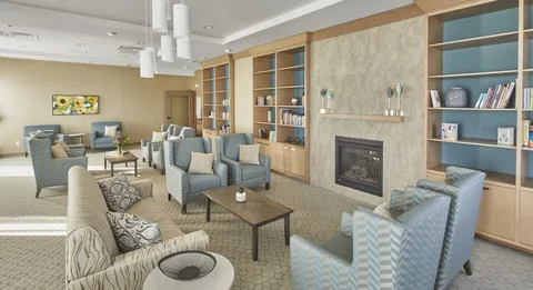 Room with bookshelves, sofas, armchairs and a fireplace
