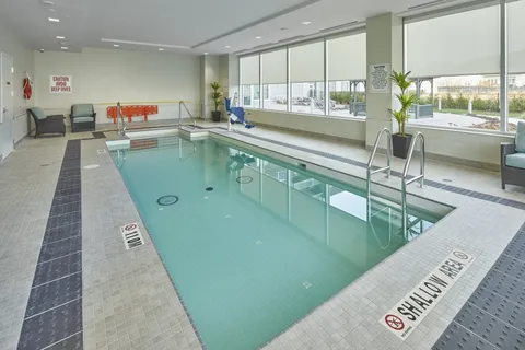 Indoor swimming pool with a handrail and large windows