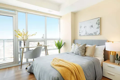 Bedroom with double bed beside floor to ceiling windows