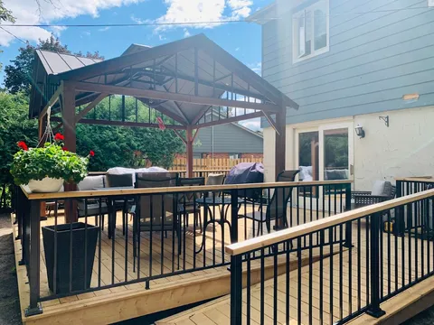 Raised deck with railings, outdoor seating and a covered gazebo.