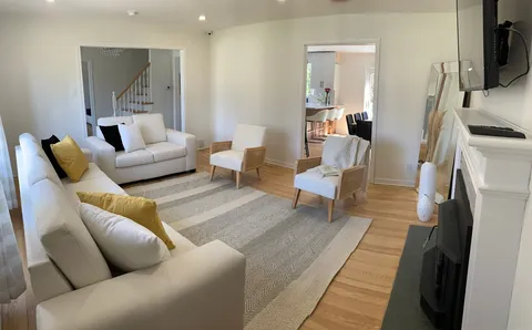 Living room with sofas, armchairs, rug and fireplace.