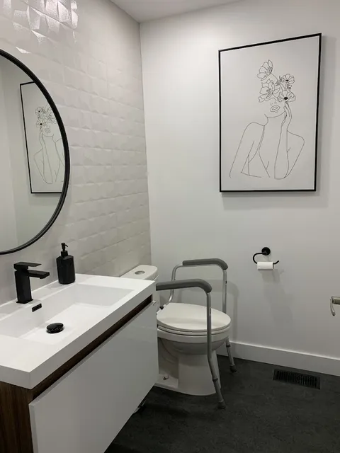 Bathroom with vanity, mirror and accessible toilet.