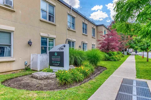 Trafalgar Lodge exterior with windows, landscaped beds and a sidewalk.