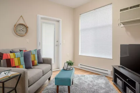 Sitting area with a sofa, turquoise bench and television