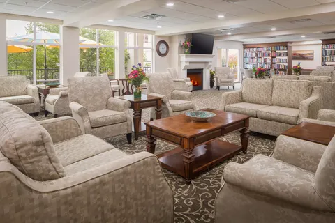 Room with sofas, armchairs, a fireplace and bookshelves
