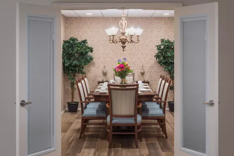 Dining table with place settings, flowers and a chandelier