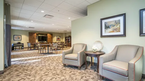 Armchairs beside tables, chairs and a television