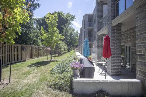 Patio umbrellas, flower pots and a lawn beside the residence
