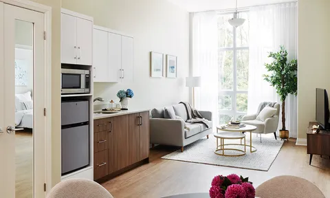 Suite sitting area and kitchen beside tall windows