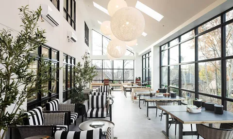 Sunlit cafe with black and white chairs beside glass walls