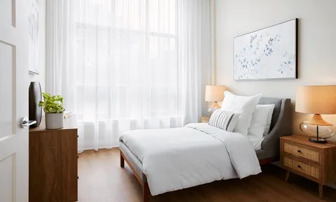 Bedroom with double bed beside floor to ceiling curtains