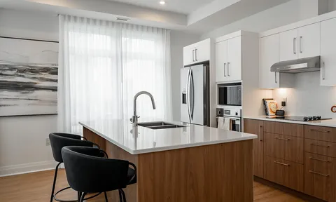 Suite kitchen with white cabinets and a dark island
