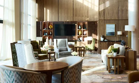 Lounge seating with wood cabinetry and tall windows